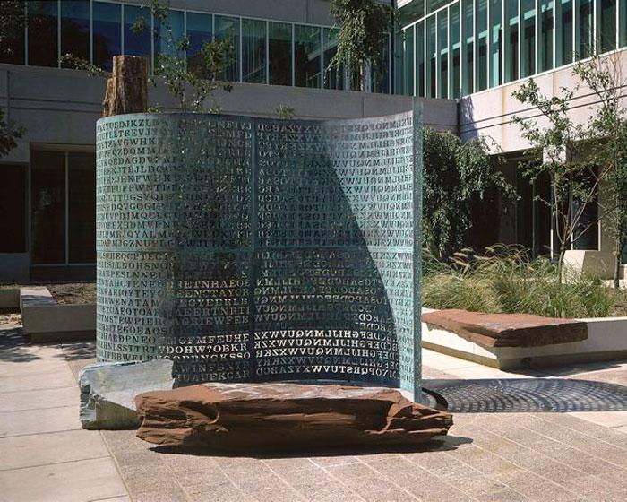Kryptos sculpture outside CIA headquarters, a curved copper screen engraved with four panels of encrypted code. A story from Peregrune Runner Journal