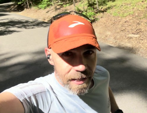 A middle-aged runner jogging outdoors at sunrise, focused on long-term fitness and consistency. Using runner vitamins and supplements